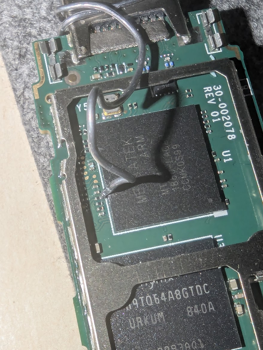 Solder wire held against the CLK point on the board